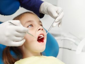 niña en consulta con el odontopediatra